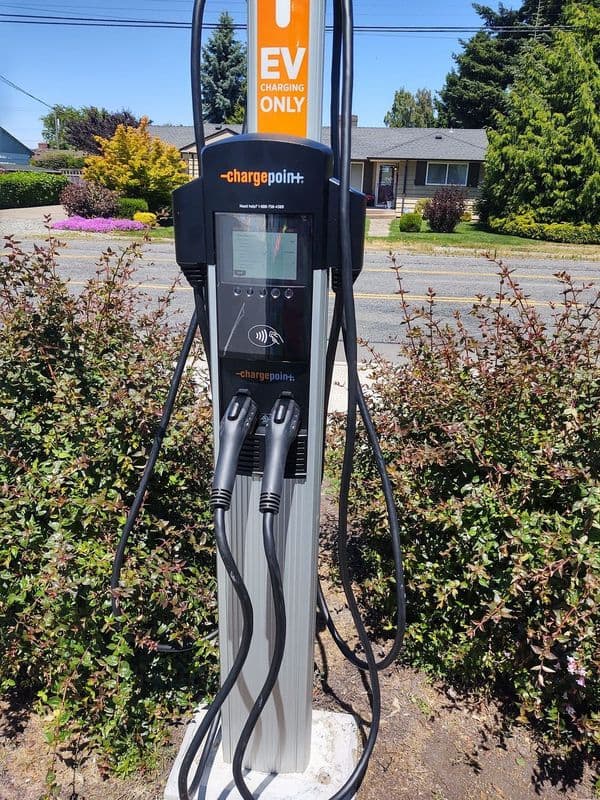 ChargePoint EV charging station with dual connectors in a residential area.
